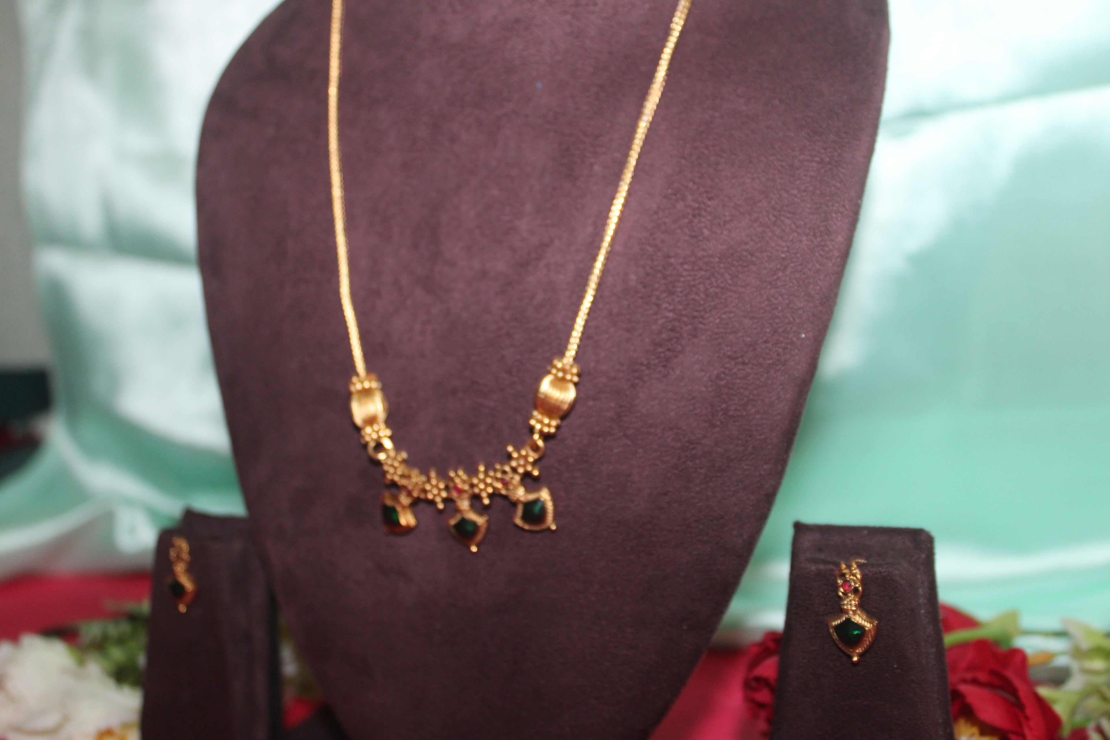 Simple neck chain with green stones and nakshi balls with earings